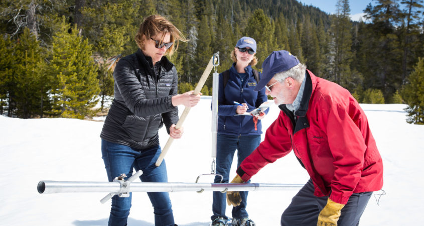 Karla Nemeth, Director of the California Department of Water Resources, left, Cindy Messer, Chief Deputy Director (DWR), center, assists Frank Gehrke, Chief of the California Cooperative Snow Surveys Program, with the fourth snow survey of 2018 at Phillips Station in the Sierra Nevada Mountains. The survey site is approximately 90 miles east of Sacramento off Highway 50 in El Dorado County. Photo: Dale Kolke / California Department of Water Resources