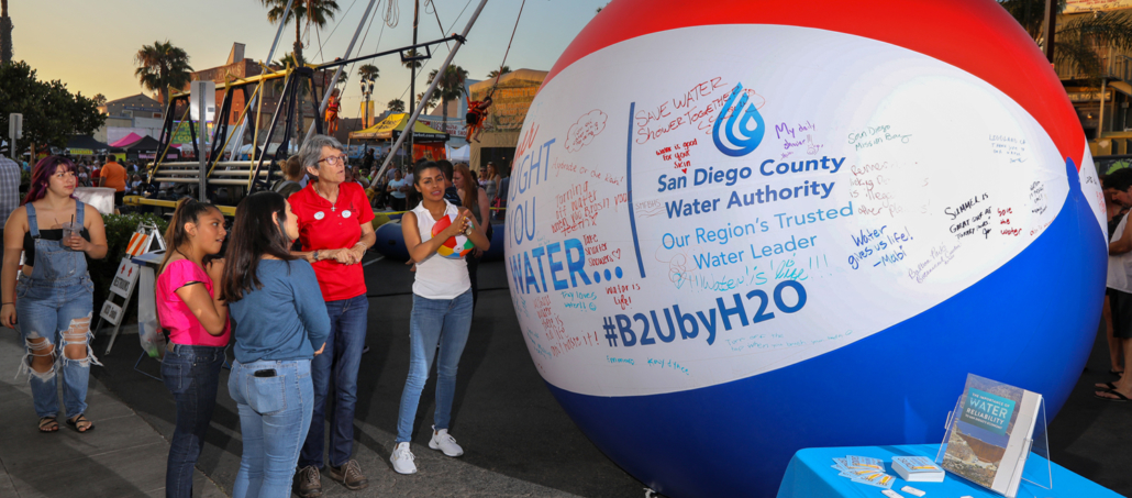 Visitors to the Oceanside Sunset Market get a close look at the topics written on the 'Brought To You By Water' beach ball. Photo: Charlie Neuman, Water Authority