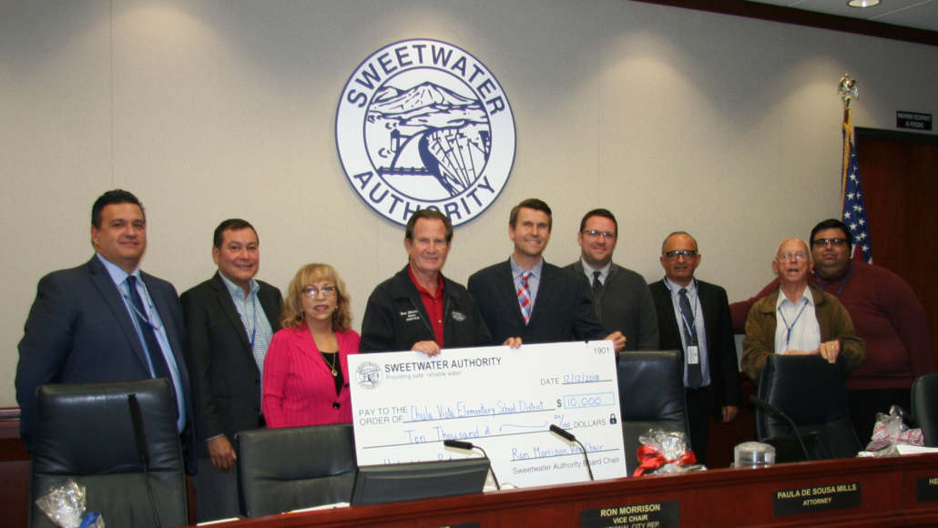 (L to R) Sweetwater Authority Directors José F. Cerda, Steve Castaneda, Josie Calderon-Scott; former Director Ron Morrison; Director Dr. Matthew Tessier, Chula Vista Elementary School District Assistant Superintendent, Innovation and Instruction; and Michael Bruder, Resource Teacher, Innovation and Instruction; Director Hector Martinez; former Director Jess Van Deventer, and Director Jose Preciado receive funding at a December 12, 2018 board meeting. Photo: Sweetwater Authority