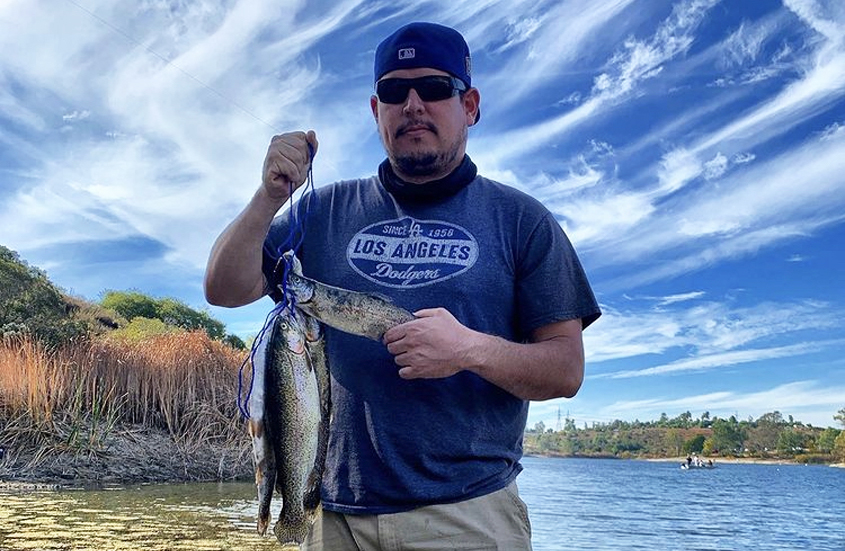 Showing off a string of rainbow trout along with the beautiful Lake Jennings scenery. Photo: Lake Jennings trout season