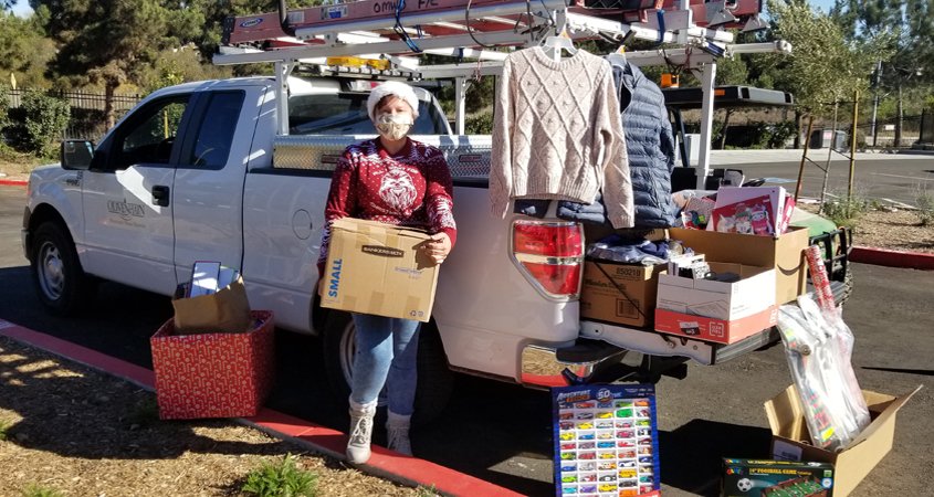 Teresa Chase helps load up donations from Olivenhain Municipal Water District employees. They are playing Santa Claus to a family of seven, a local senior, and a veteran in its annual adopt-a-family effort, and filled a truck bed with donations for the San Diego Humane Society. Photo: Olivenhain Municipal Water District