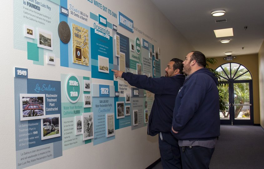 City of Oceanside employees Carlos Raymundo (closest) and Shawn Alonzo view the award-winning Pure Water Oceanside wall art project. Photo: City of Oceanside