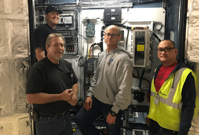 Helix’s ozone project team (pre-pandemic) in front of the rebuilt power supply unit.