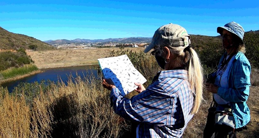 Naturalists Paige DeCino (left) and Karen Merrill survey South Lake Reservoir. Photo: Vallecitos Water District