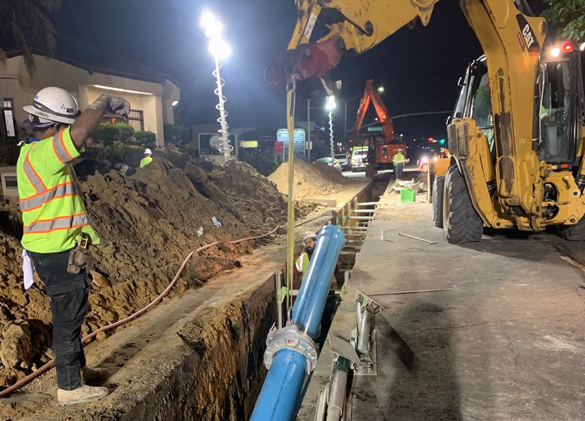 Lowering a section of the new potable water pipe into a trench in El Camino Real joint project by OlivenhainLowering a section of the new potable water pipe into a trench in El Camino Real joint project by Olivenhain