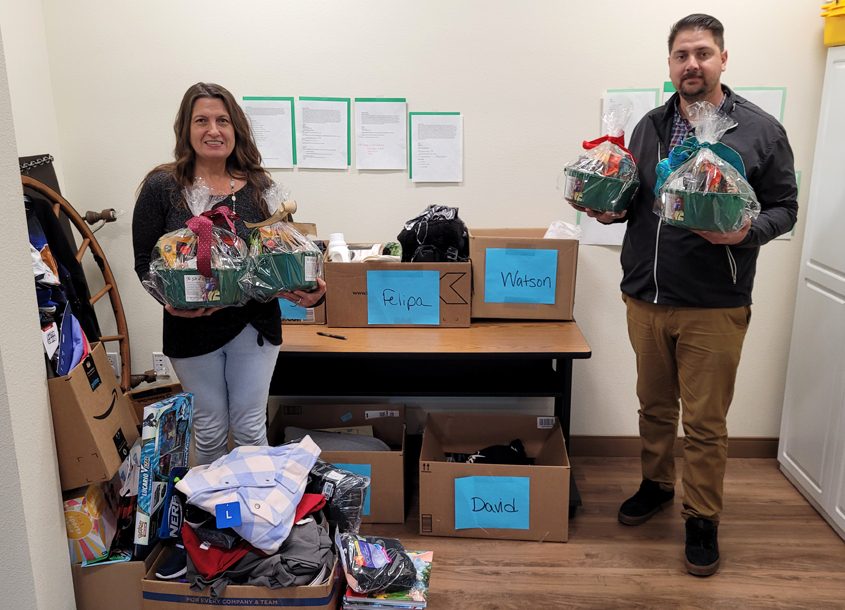 Olivenhain Municipal Water District “elves” Tammi Bowman and Paul Martinez show off donated nut baskets in front of “adoption” collection boxes. Photo: Olivenhain Municipal Water District 