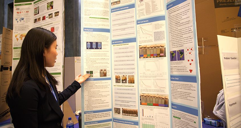 A student at the science fair showcases her project board. Innovation-technology