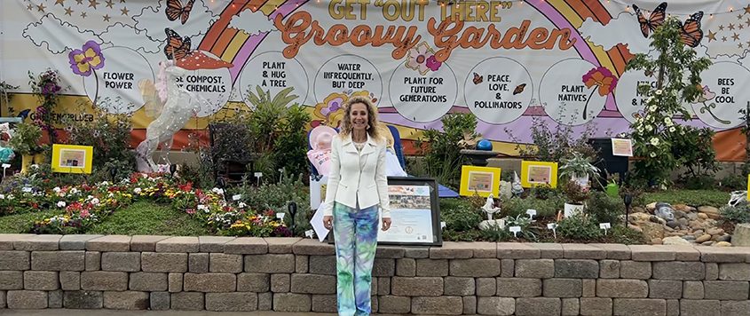 Water Resources Specialist Debby Dunn poses with her "Groovy Garden" exhibit. Photo: Debby Dunn