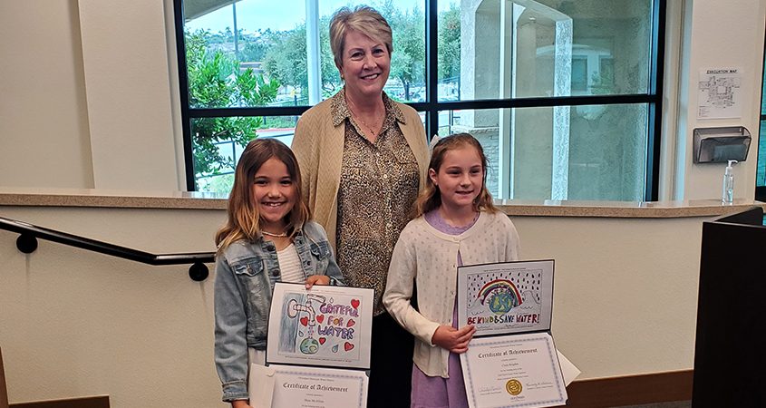 Poster contest winning artists Aria Drelich and Maia McAllum with OMWD Board President Christy Guerin. Photo: Olivenhain Municipal Water District