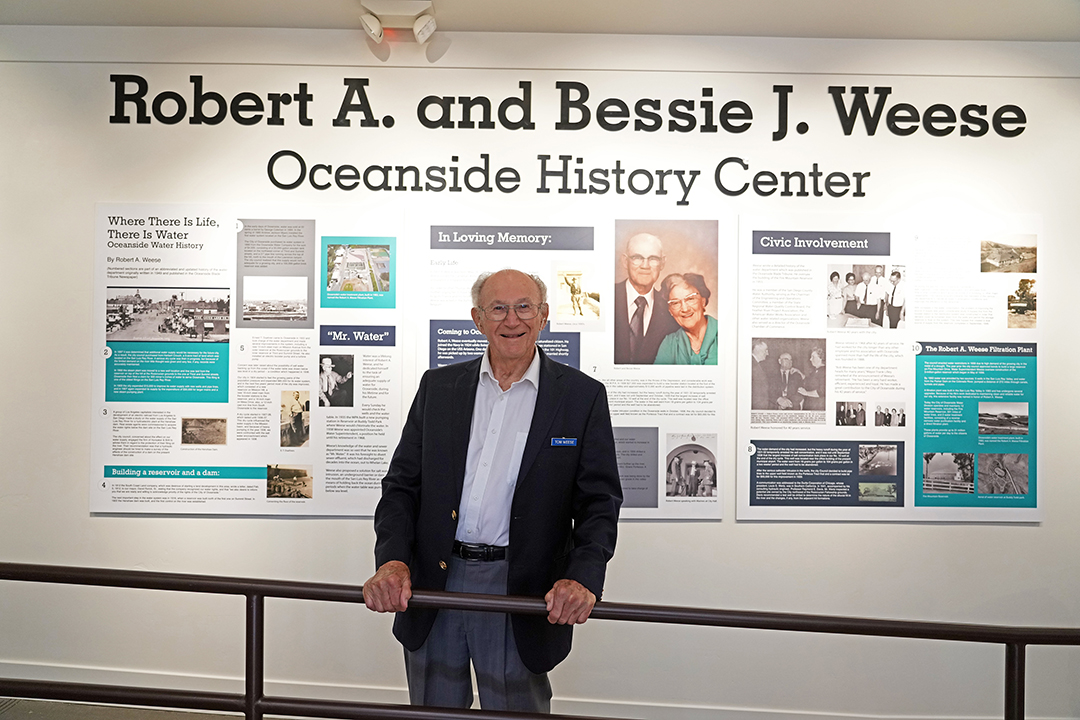 Tom Weese, son of Robert and Bessie Weese, in front of an exhibit honoring his parents at the Reese Oceanside History Center. Photo: Zach Cordner/The Osider.