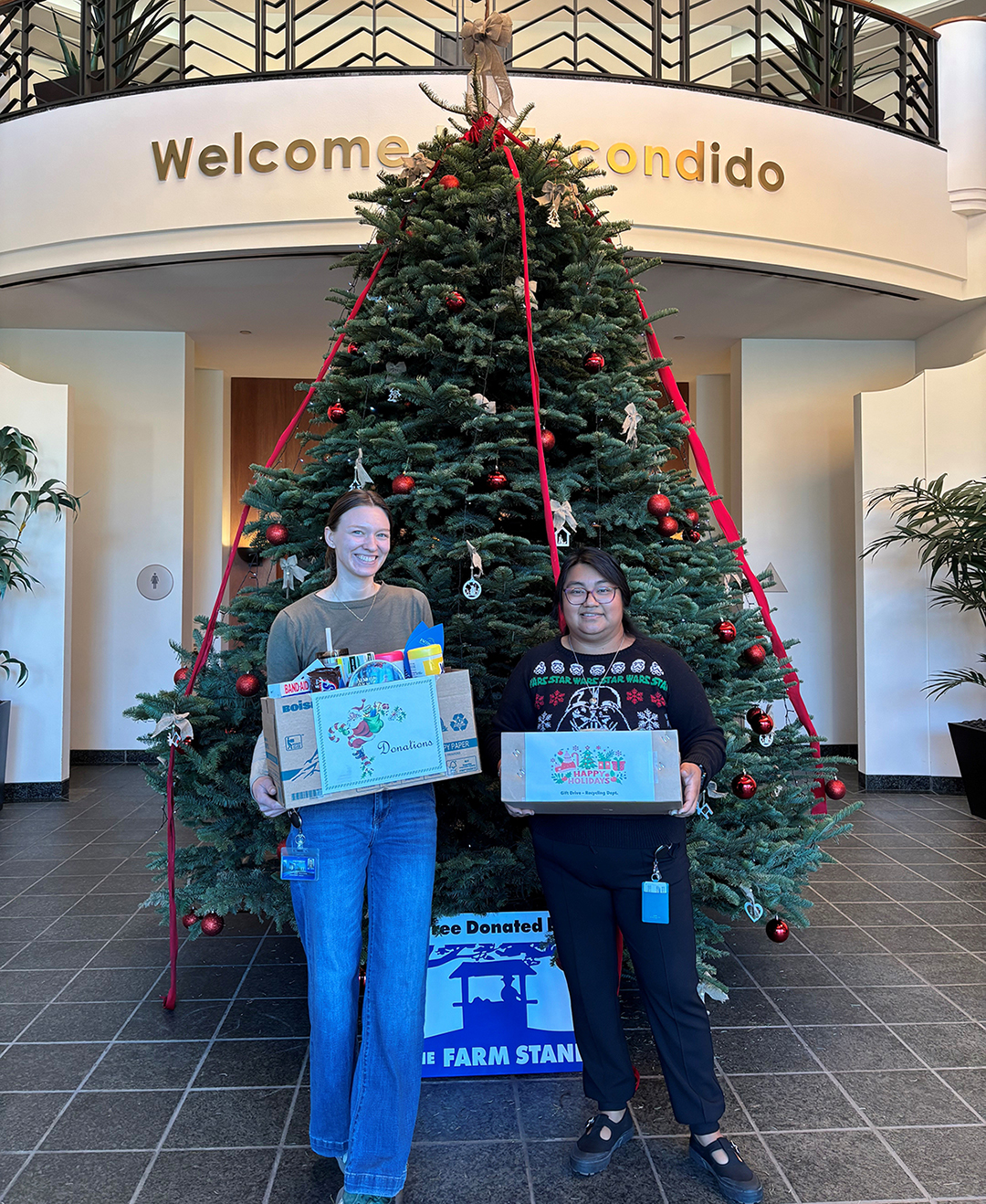 City of Escondido Utilities employees Emma Potratz, Environmental Programs Specialist, and Gio Cortes, Recycling Programs Specialist, play Santa Elves with holiday donations from city employees. Photo: City of Escondido