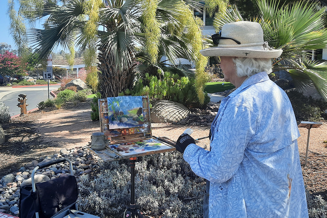 Plein air artist Kathy Fortenberry paints palm trees at the Vallecitos Sustainable Demonstration Garden. Photo: Vallecitos Water District